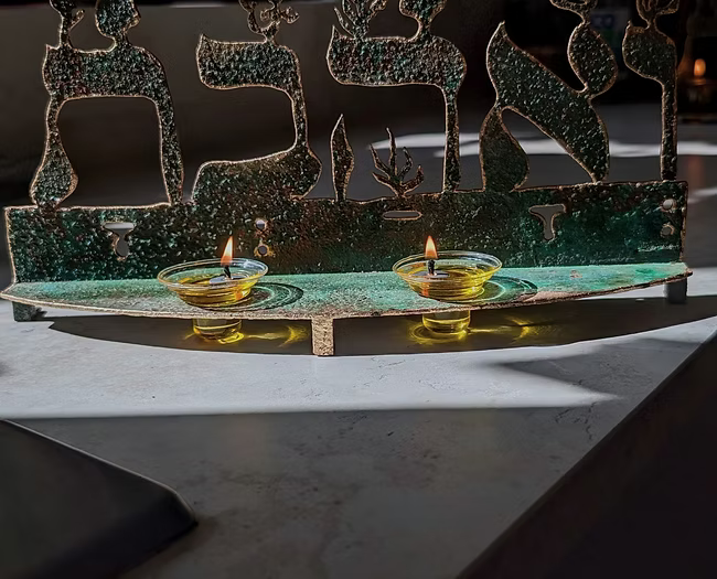 פמוט לנרות שבת “ואהבת”. נחושת יצוקה ידנית על ברזל, זוג קני זכוכית פיירקס ופתיליו