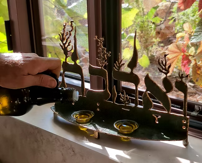 פמוט לנרות שבת “ואהבת”. נחושת יצוקה ידנית על ברזל, זוג קני זכוכית פיירקס ופתיליו